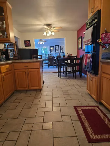 a kitchen with stainless steel appliances kitchen island granite countertop a refrigerator and cabinets
