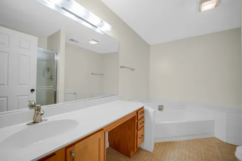 a bathroom with a tub sink and a mirror