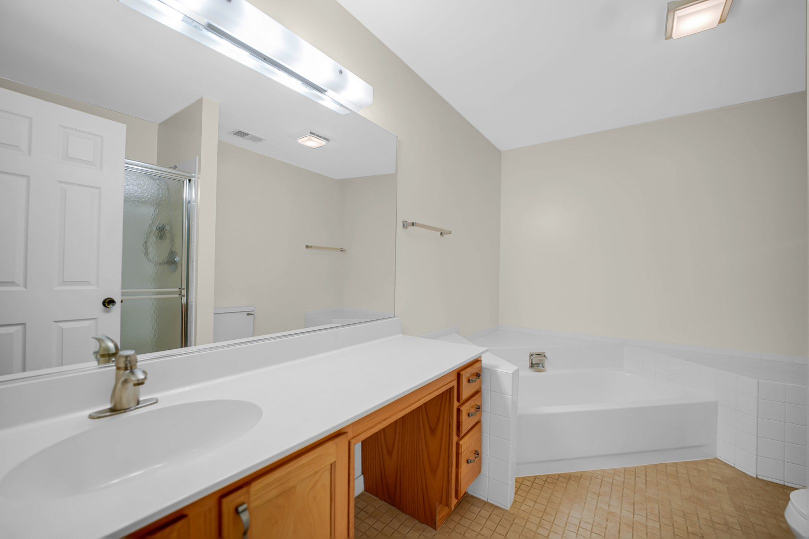 62 Winding Run Lane, Unit 62 Streamwood, IL 60107 - Photo 12 of 20 a bathroom with a tub sink and a mirror