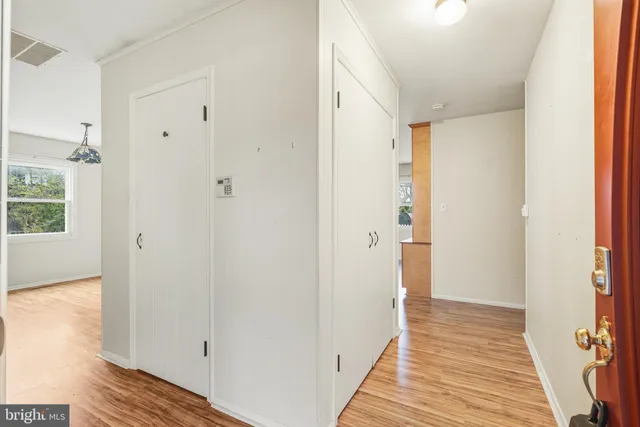 a view of a hallway with wooden floor and staircase
