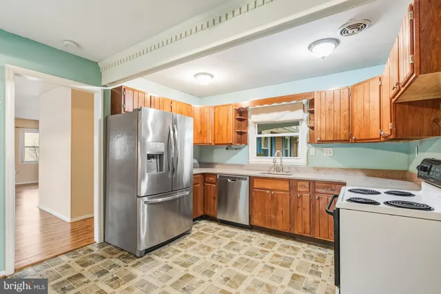 a kitchen with stainless steel appliances granite countertop a refrigerator and a sink
