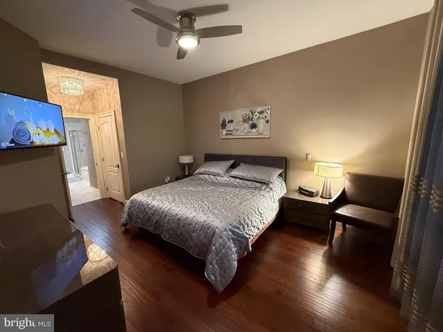 a spacious bedroom with a bed and wooden floor