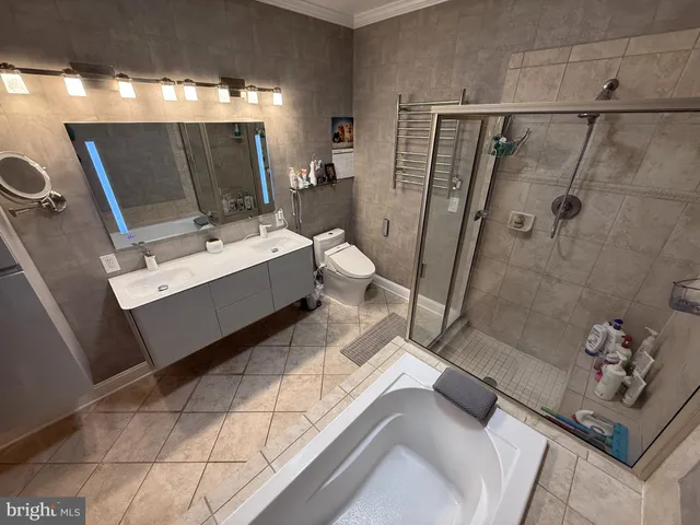a bathroom with a tub sink mirror and shower