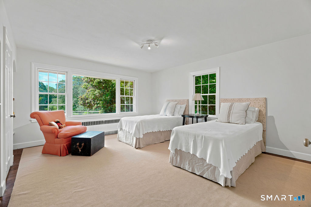 261-1 Grassy Hill Road Lyme, CT 06371 - Photo 21 of 40 Generously sized and filled with natural light, this bedroom offers ample space for twin beds while overlooking the picturesque backyard.