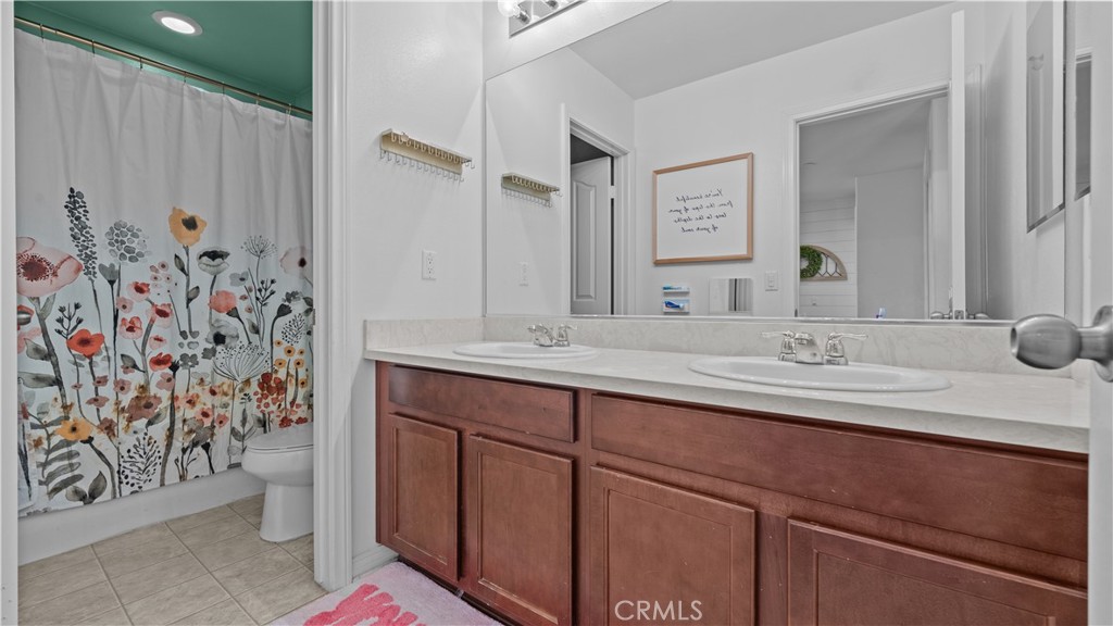 3641 Bur Oak Road San Bernardino, CA 92407 - Photo 17 of 20 a bathroom with a granite countertop sink a toilet and a mirror