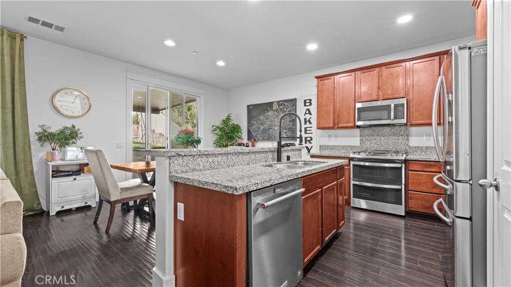 3641 Bur Oak Road San Bernardino, CA 92407 - Photo 5 of 20 a kitchen with a table chairs sink and cabinets
