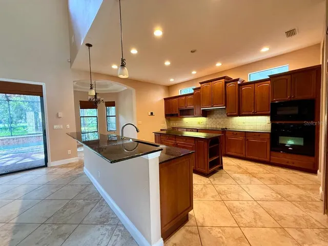 a view of a room with wooden floor chandelier and windows