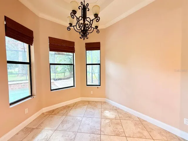 a view of a room with wooden floor chandelier and windows