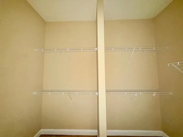 a view of an empty room with a ceiling fan and window