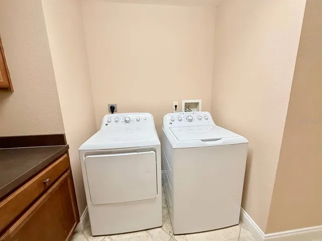 a dining room with wooden floor a chandelier a glass table and chairs