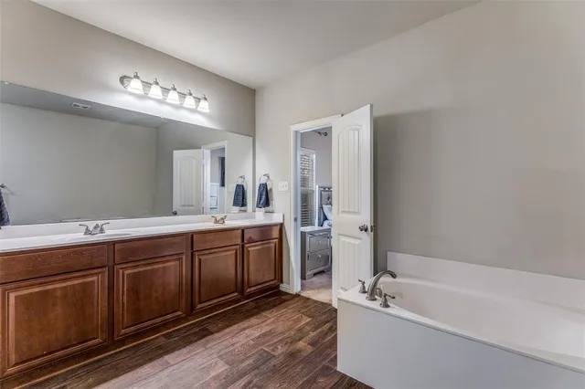 a spacious bathroom with a tub sink and mirror