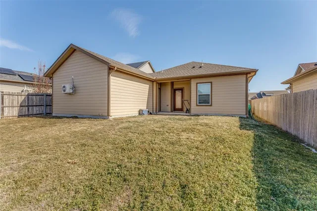 a house with yard and tree in front of it