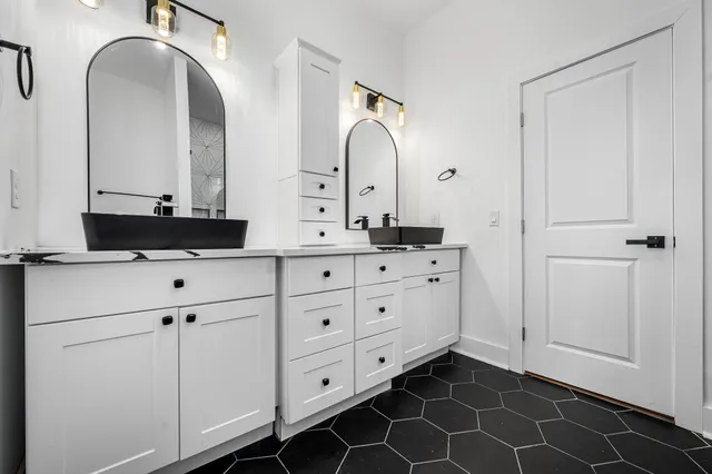 a bathroom with a double vanity sink and mirror
