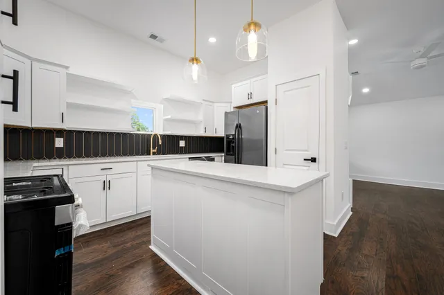 a kitchen with white cabinets and stainless steel appliances