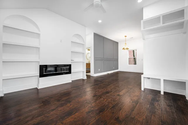a view of a room with wooden floor and electronic appliances