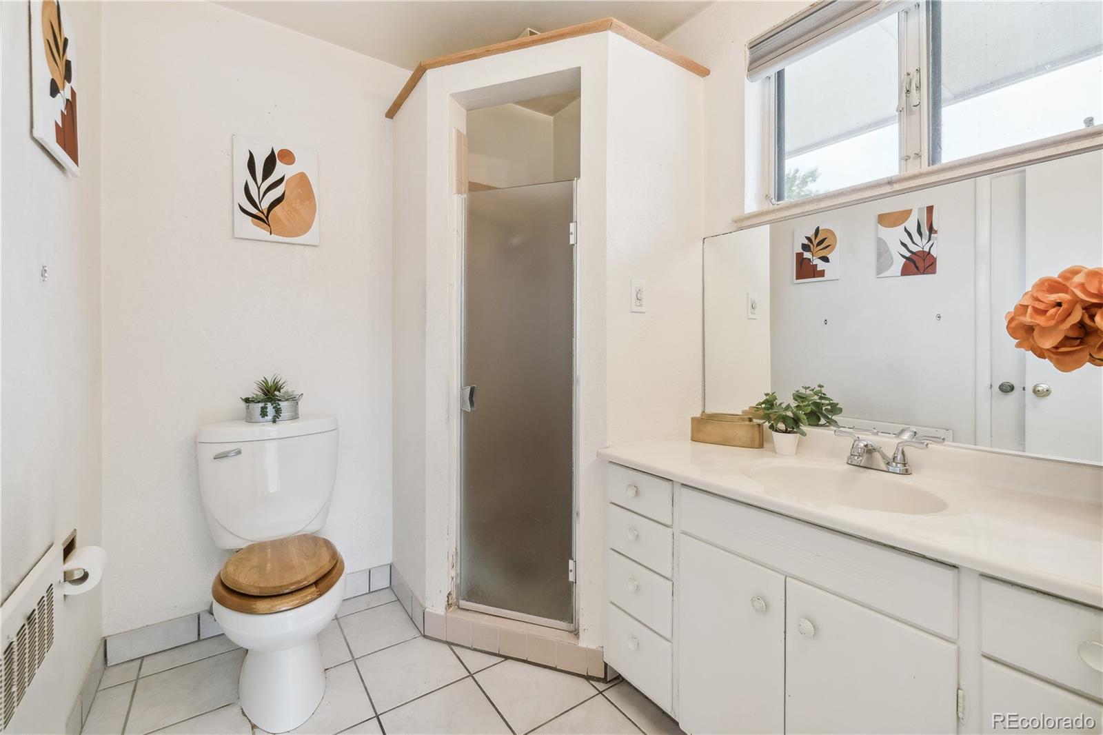 4185 Pierce Street Wheat Ridge, CO 80033 - Photo 12 of 27 a bathroom with a sink a toilet and a mirror