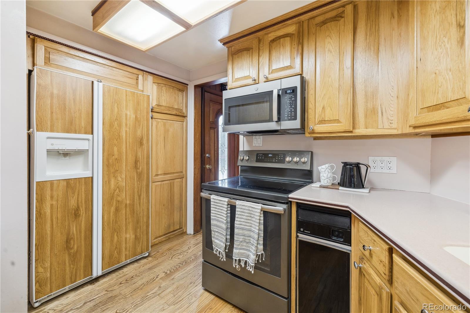 4185 Pierce Street Wheat Ridge, CO 80033 - Photo 7 of 27 a kitchen with stainless steel appliances granite countertop a stove and a refrigerator