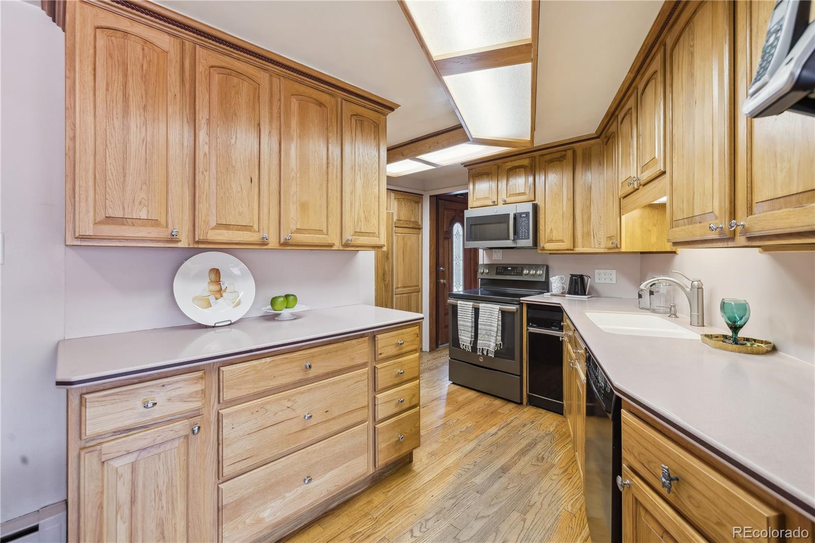 4185 Pierce Street Wheat Ridge, CO 80033 - Photo 9 of 27 a kitchen with stainless steel appliances granite countertop a sink a stove and cabinets