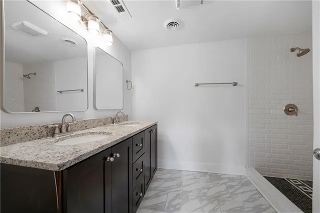 a bathroom with a granite countertop sink and a mirror