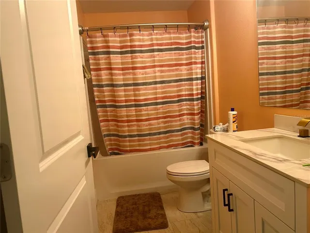 a bathroom with a granite countertop toilet a sink and a shower