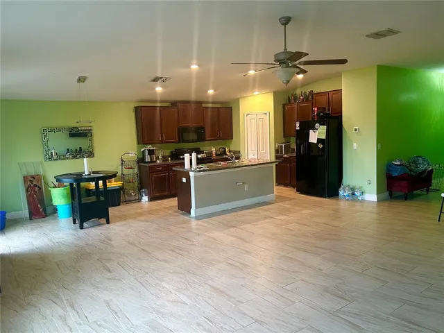 a kitchen with stainless steel appliances granite countertop a refrigerator a sink and a stove