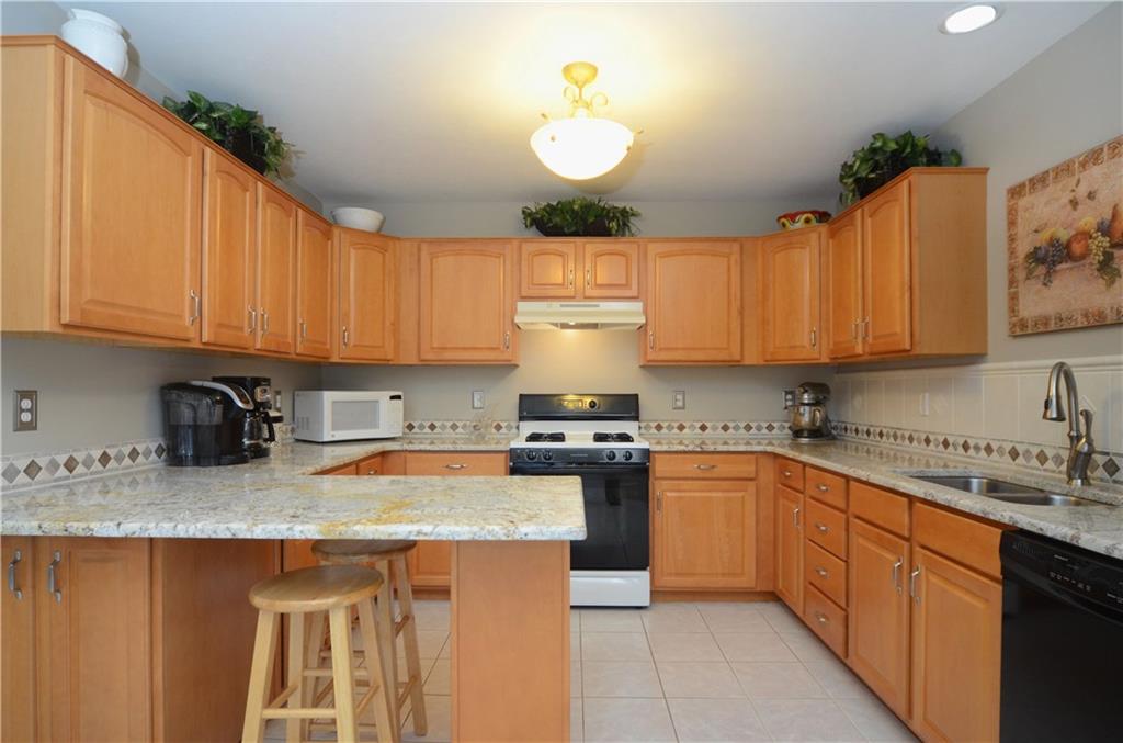 4000 Oak Point Circle McKees Rocks, PA 15136 - Photo 7 of 25 Lovely Kitchen with maple cabinets, granite counters, stainless undermount sink and faucet, and custom ceramic tile backsplash. Peninsula in kitchen is great for serving up breakfast or buffet style meals.