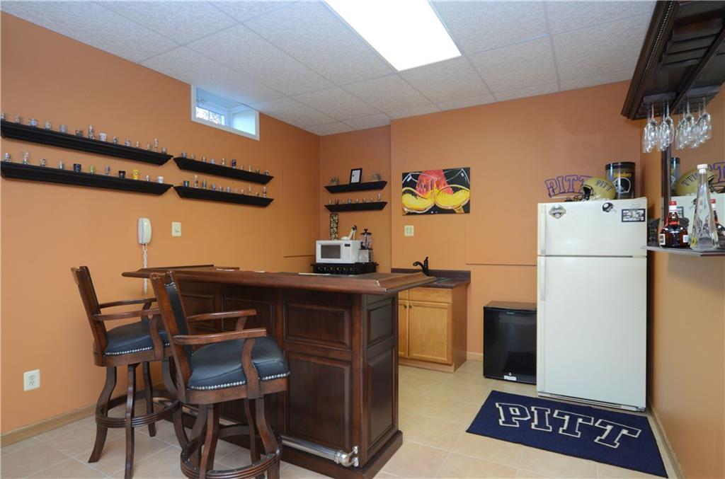 4000 Oak Point Circle McKees Rocks, PA 15136 - Photo 10 of 25 Full Bar on Lower Level is so great for entertaining! Bar, stools and full size refrigerator all included. Offers full sink too for rinsing glasses or fill with ice and use as a dispenser for cool beverages.
