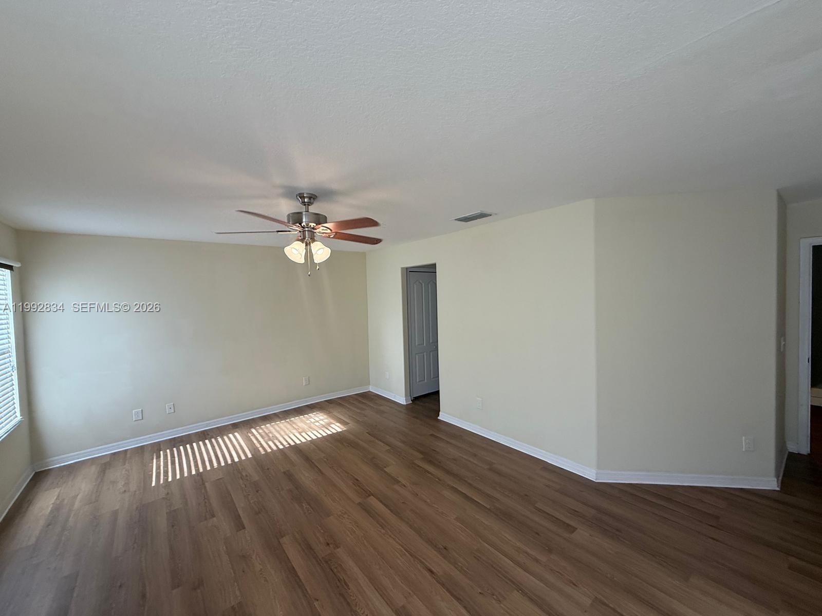 3154 Rodrick Circle Orlando, FL 32824 - Photo 14 of 21 wooden floor in an empty room with a window