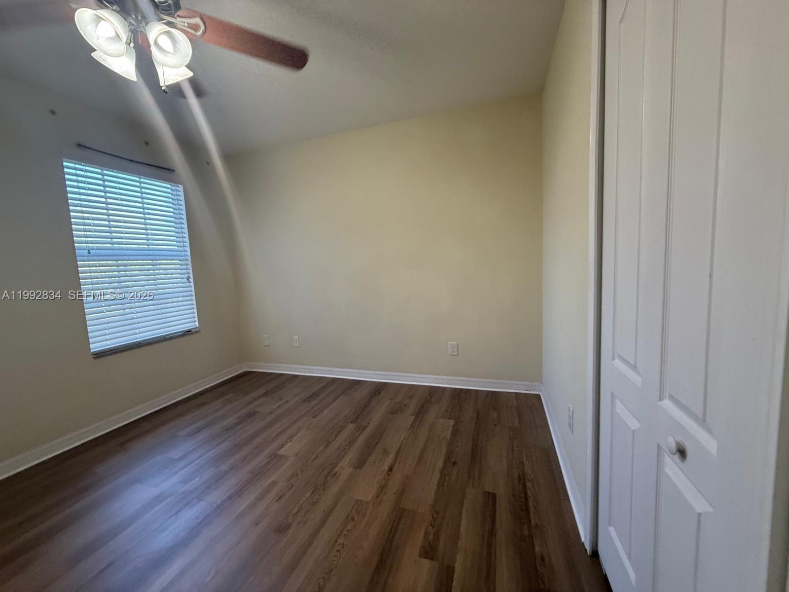 3154 Rodrick Circle Orlando, FL 32824 - Photo 17 of 21 a view of an empty room with wooden floor and a window