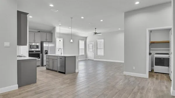 a kitchen with kitchen island a sink stainless steel appliances and cabinets