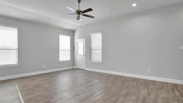 a large white kitchen with a large window stainless steel appliances cabinets and a sink