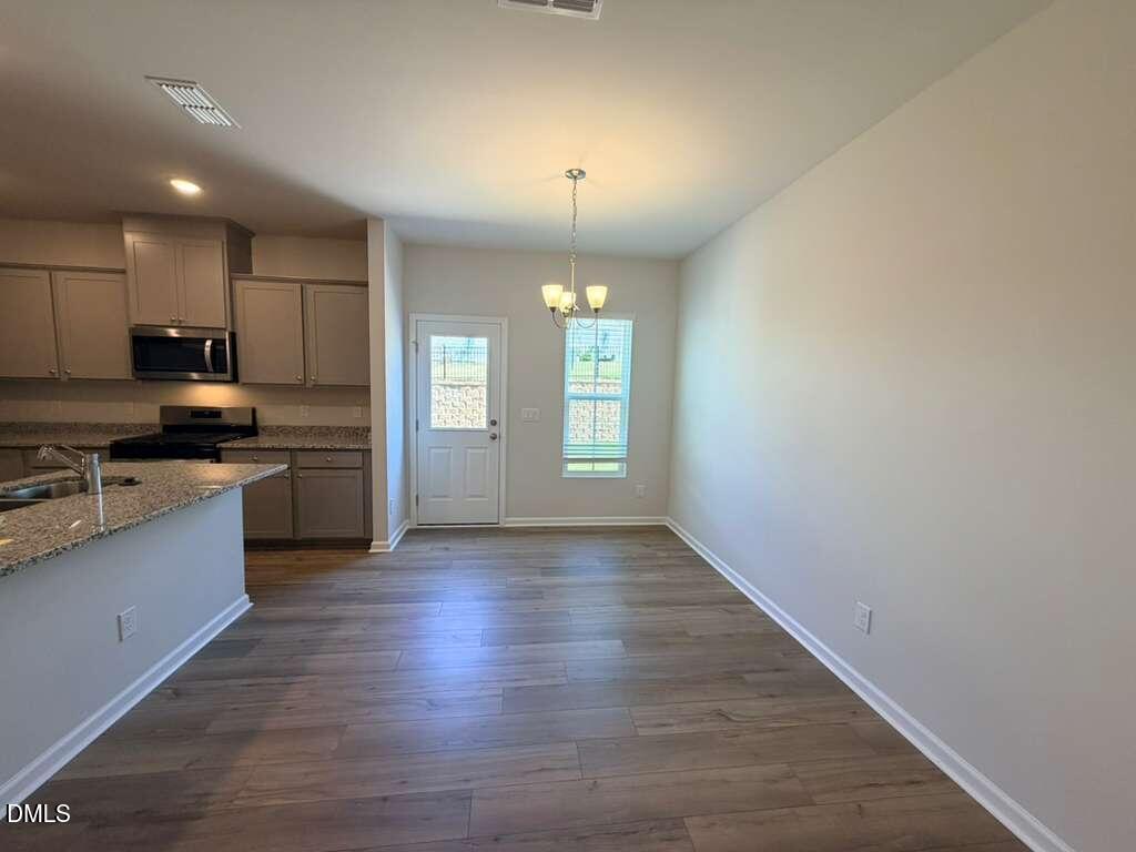 5024 Reader Way Durham, NC 27703 - Photo 5 of 26 a large kitchen with hardwood floor a sink a window and appliances