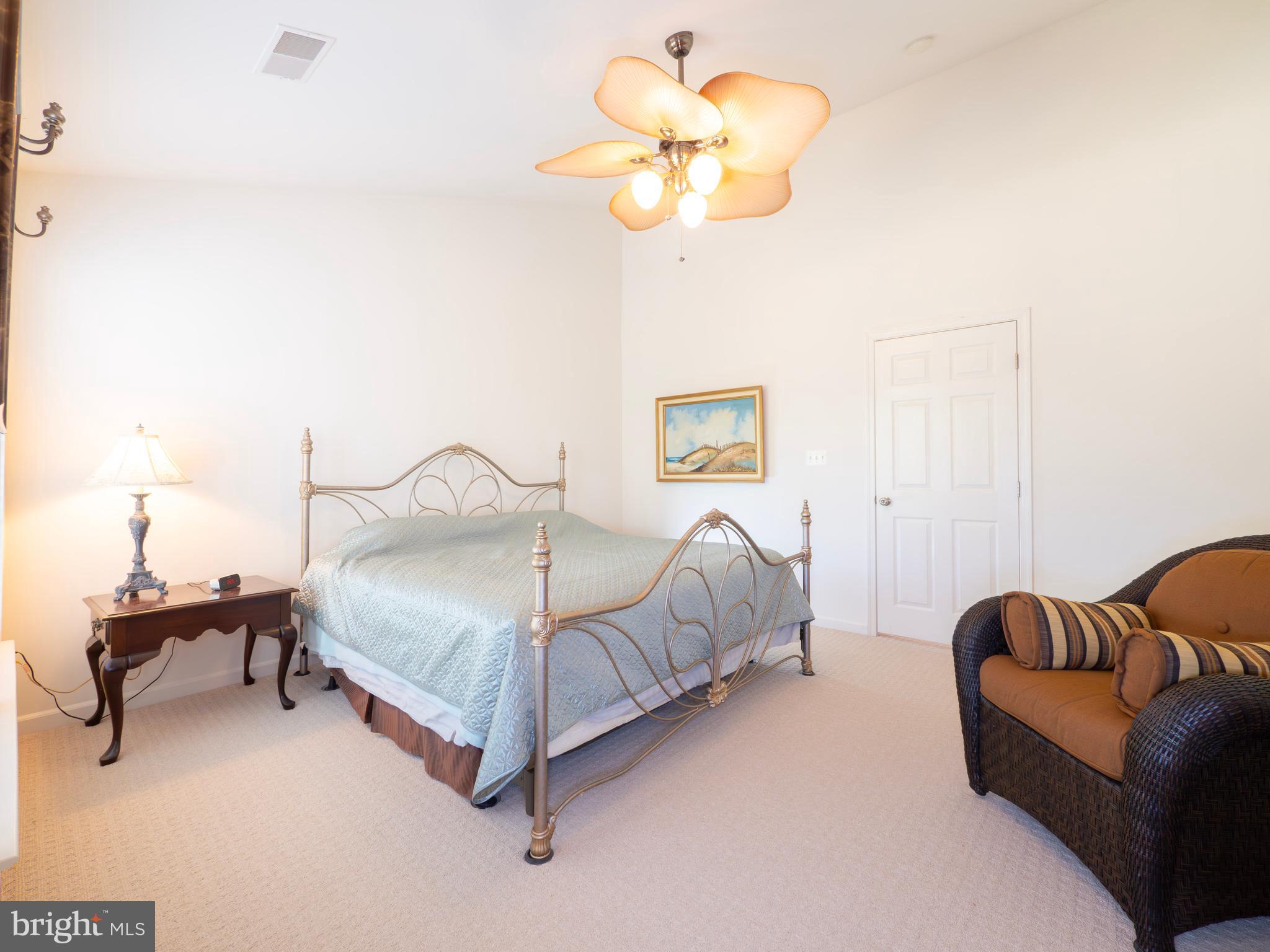 301 Monroe Point Drive Colonial Beach, VA 22443 - Photo 19 of 33 a bedroom with a bed couch and a chandelier