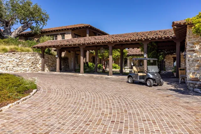 a view of a house with large trees and playing area