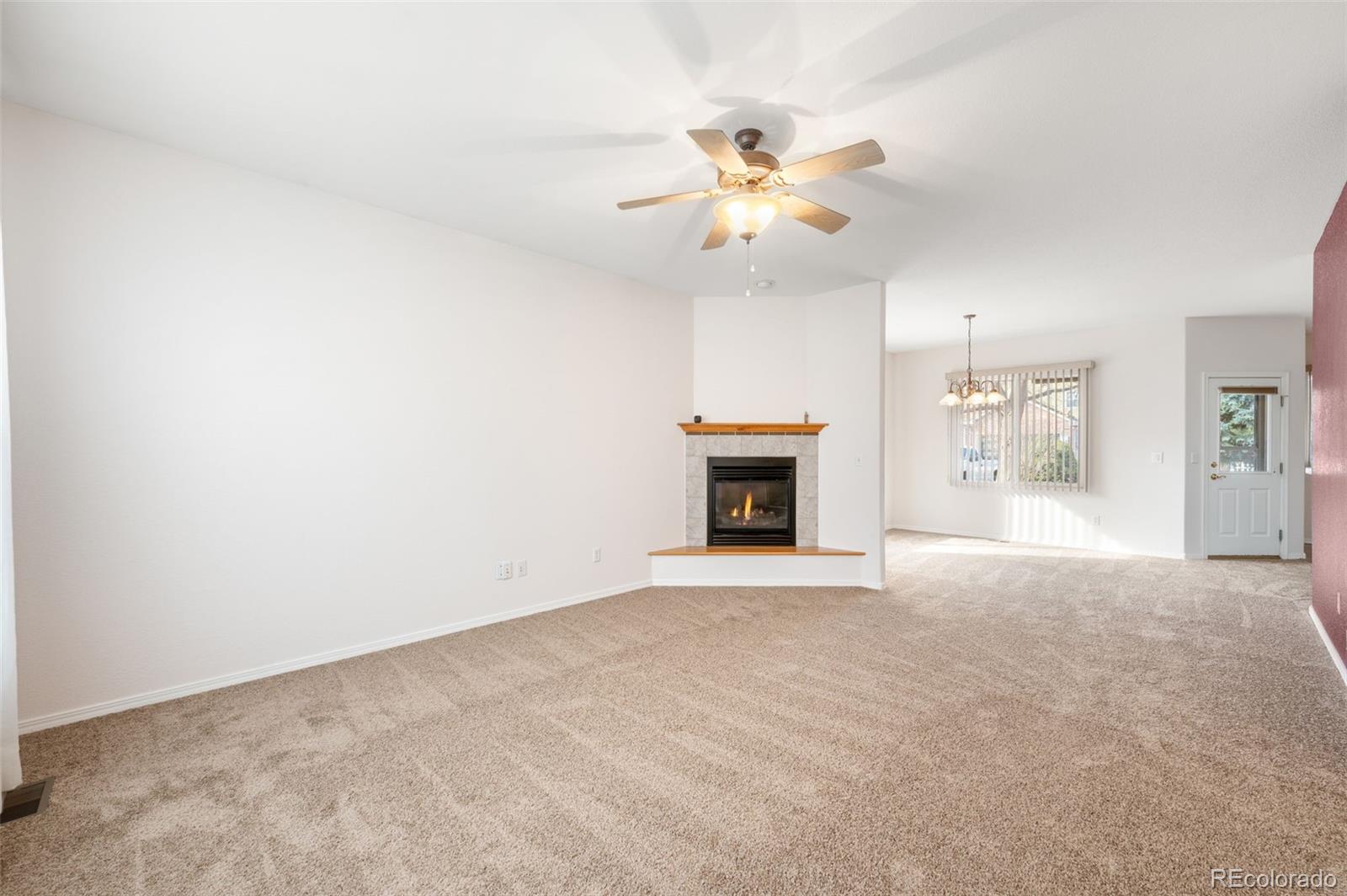 203 Hubbell Street Berthoud, CO 80513 - Photo 11 of 49 an empty room with windows and fireplace