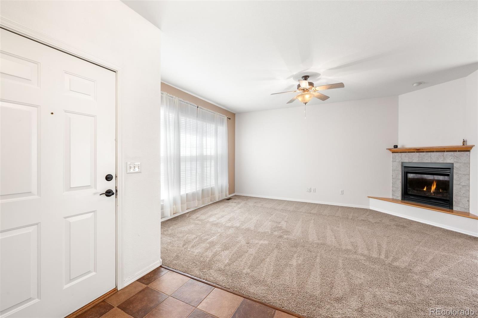 203 Hubbell Street Berthoud, CO 80513 - Photo 8 of 49 a view of a livingroom with a fireplace and a chandelier fan