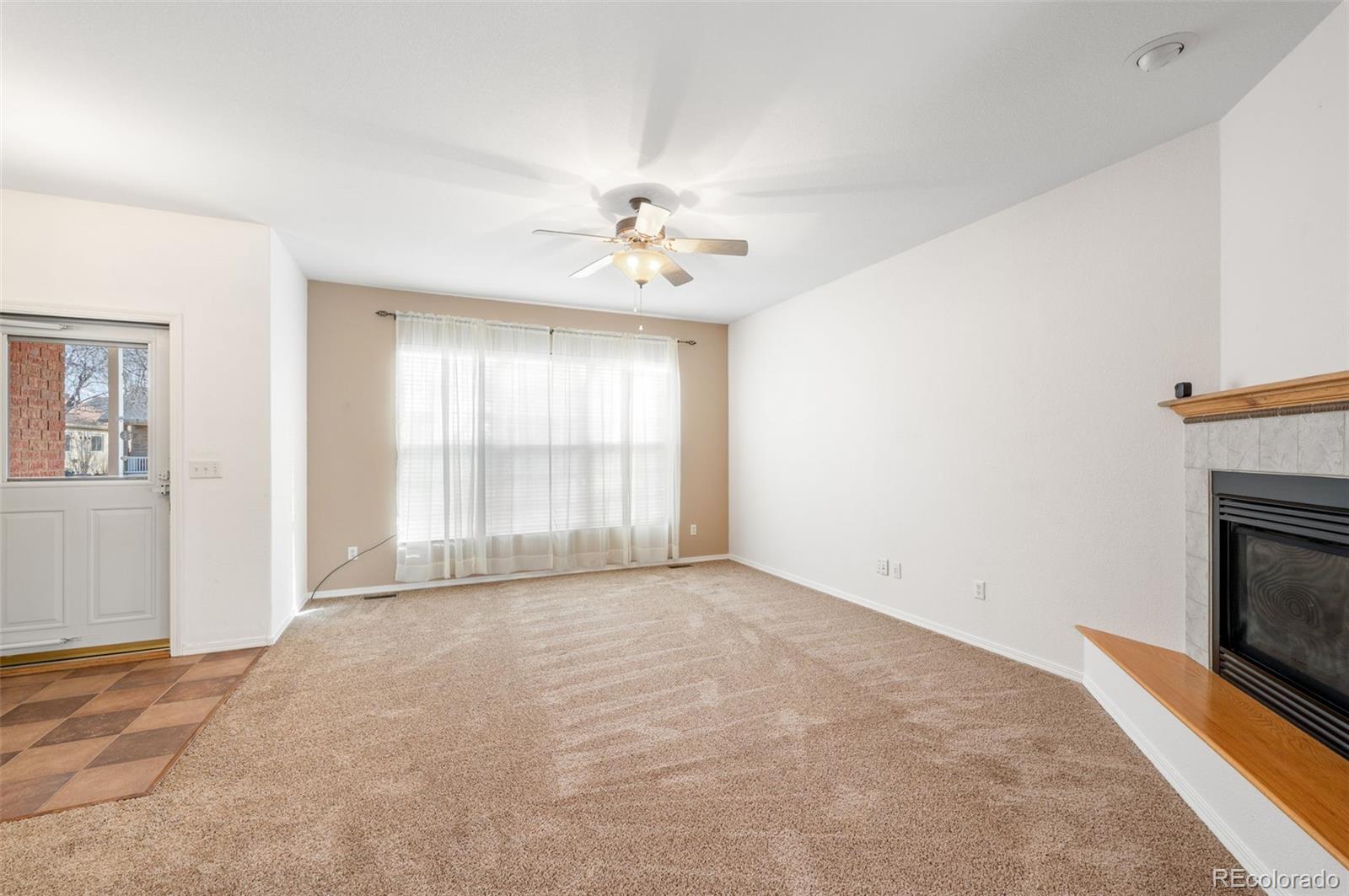 203 Hubbell Street Berthoud, CO 80513 - Photo 9 of 49 a view of an empty room with a fireplace and a window