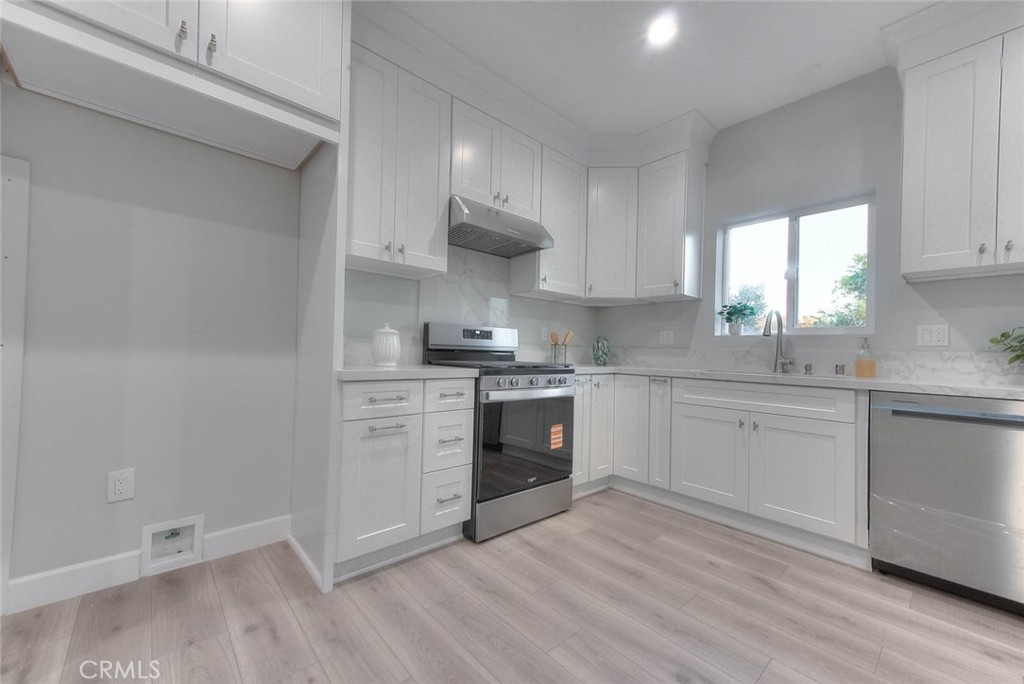 752 Rio Del Sol Avenue Montebello, CA 90640 - Photo 20 of 62 a kitchen with a white cabinets and wooden floor