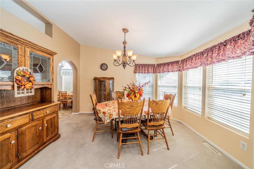 22241 Nisqually Road, Unit 118 Apple Valley, CA 92308 - Photo 18 of 56 a dining room with furniture a chandelier and window