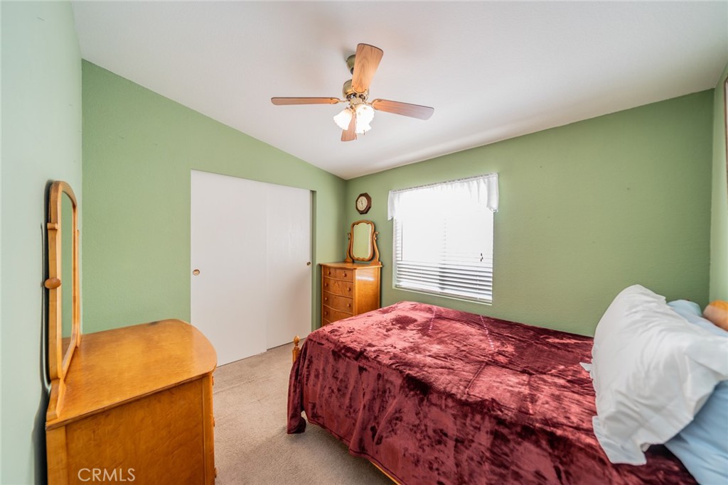 22241 Nisqually Road, Unit 118 Apple Valley, CA 92308 - Photo 20 of 56 a bedroom with a bed and a chandelier
