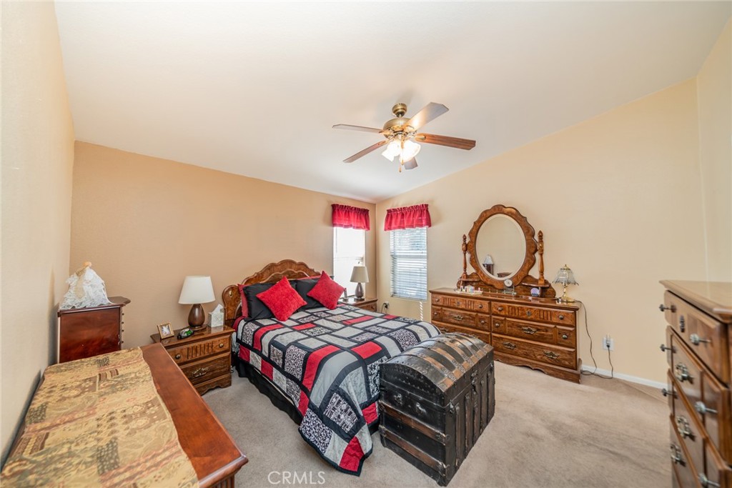 22241 Nisqually Road, Unit 118 Apple Valley, CA 92308 - Photo 22 of 56 a bedroom with a bed and a chandelier