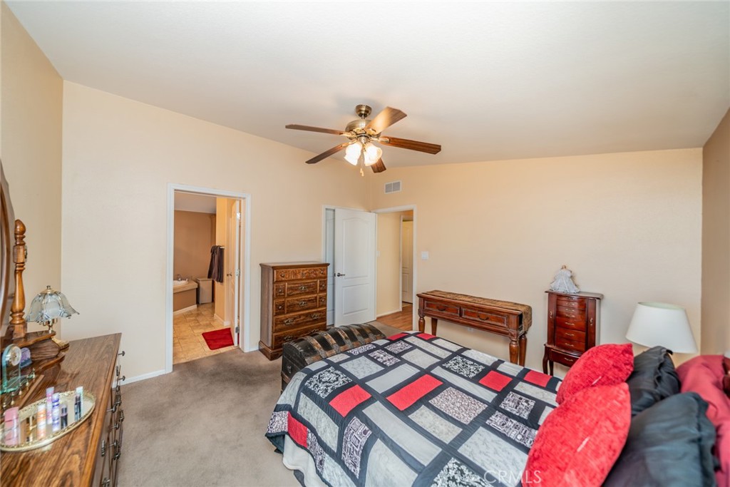 22241 Nisqually Road, Unit 118 Apple Valley, CA 92308 - Photo 24 of 56 a bedroom with a bed and a chandelier
