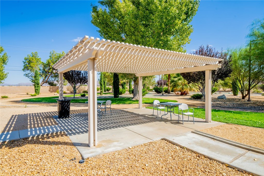 22241 Nisqually Road, Unit 118 Apple Valley, CA 92308 - Photo 47 of 56 a view of a patio with table and chairs near a yard