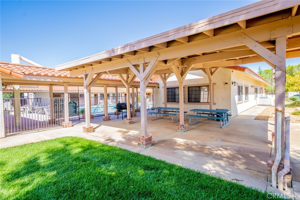 22241 Nisqually Road, Unit 118 Apple Valley, CA 92308 - Photo 52 of 56 a view of a patio with a table and chairs under an umbrella