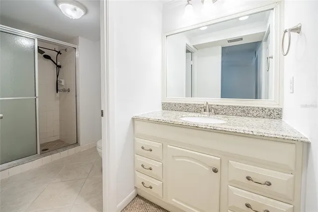 a bathroom with a granite countertop sink and a mirror