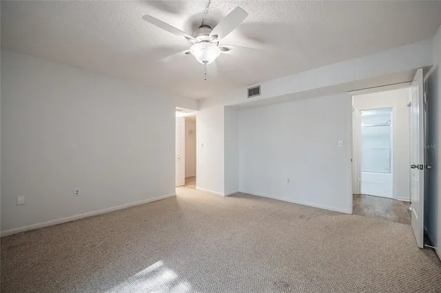 a view of an empty room with a ceiling fan