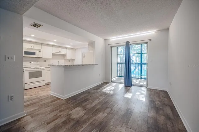 a view of a kitchen with wooden floor and a window