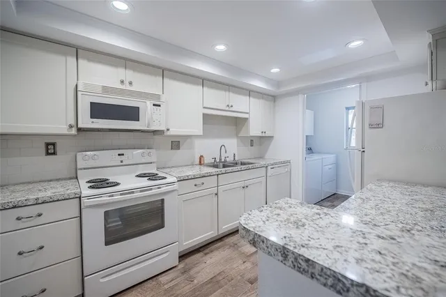 a kitchen with stainless steel appliances granite countertop a stove sink and cabinets