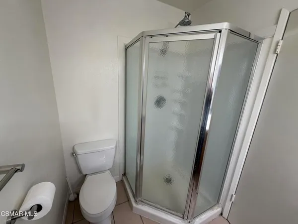 a white toilet sitting next to a shower