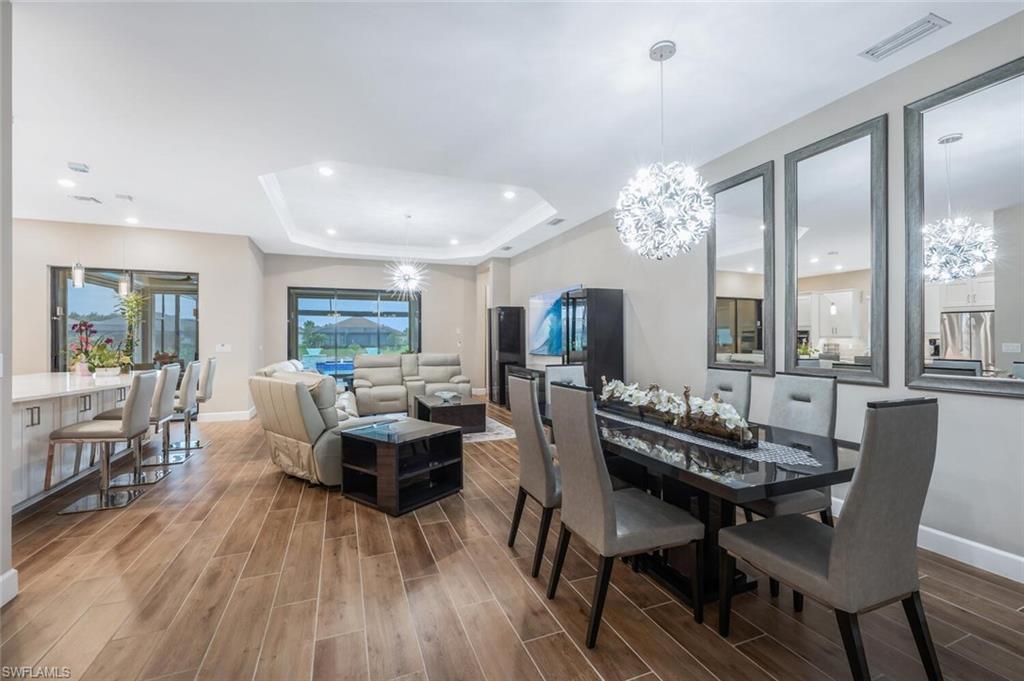 8416 Rosa Court Naples, FL 34114 - Photo 2 of 34 Open-concept living space with wood-finish flooring, recessed lighting, and a tray ceiling